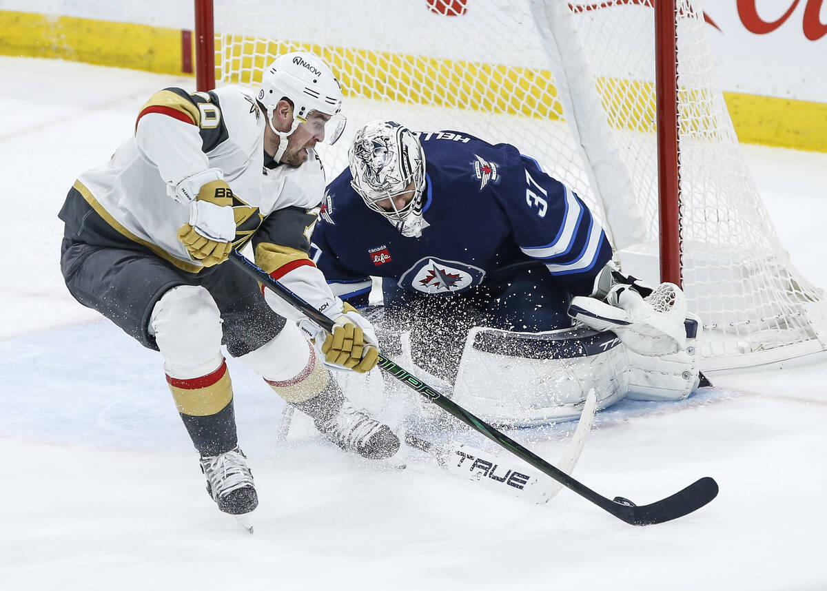 Winnipeg Jets goaltender Connor Hellebuyck (37) covers the angles against Vegas Golden Knights' ...