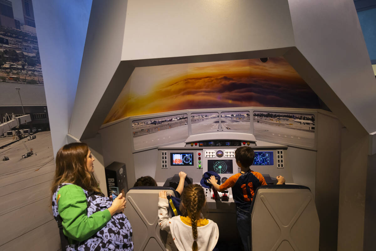 Children play inside an airplane simulator the eco city area during a tour of the Discovery Chi ...