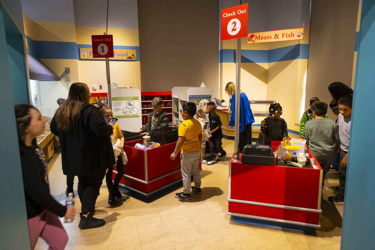 Children play in a makeshift grocery store in the eco city area during a tour of the Discovery ...