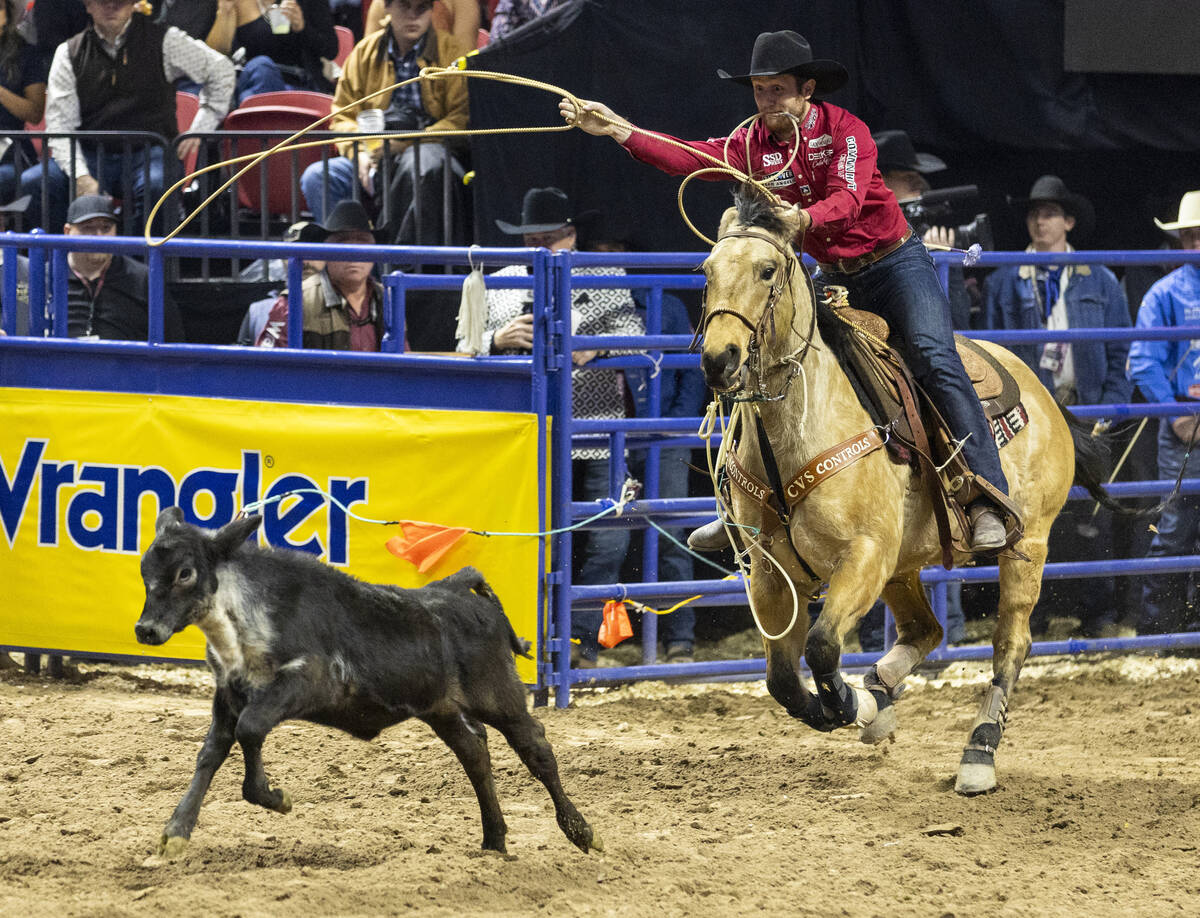 Joel Harris chases after a calf in the tie-down roping event during day nine of the National Fi ...