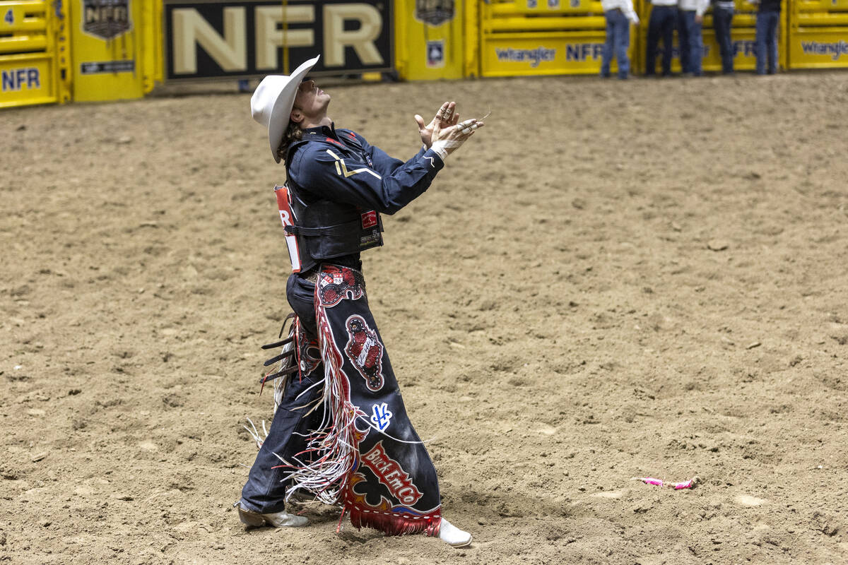 Lefty Holman claps after competing in the saddle bronc riding event during day nine of the Nati ...