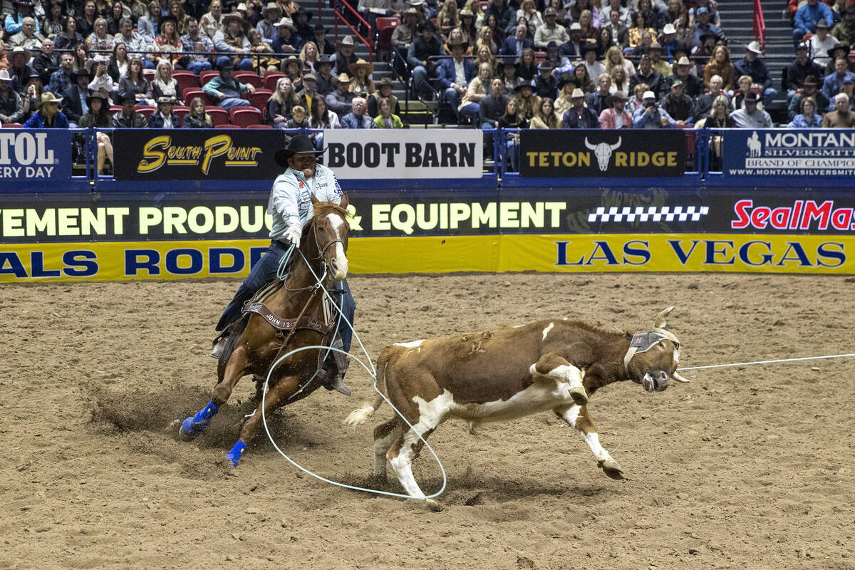 Tanner Braden attempts to rope the hind legs of a calf in the team roping event during day nine ...