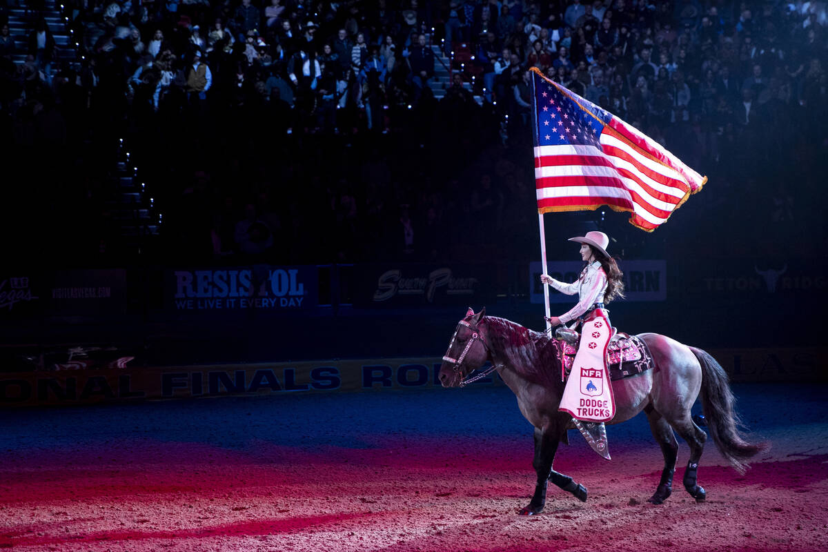 The American flag is presented before day nine of the National Finals Rodeo at the Thomas & ...