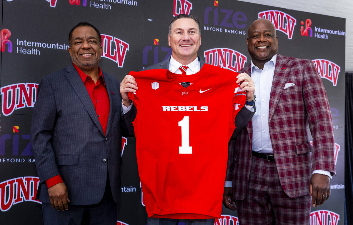 UNLV introduces Dan Mullen, center, with a jersey beside President Keith Whitfield, left, and ...