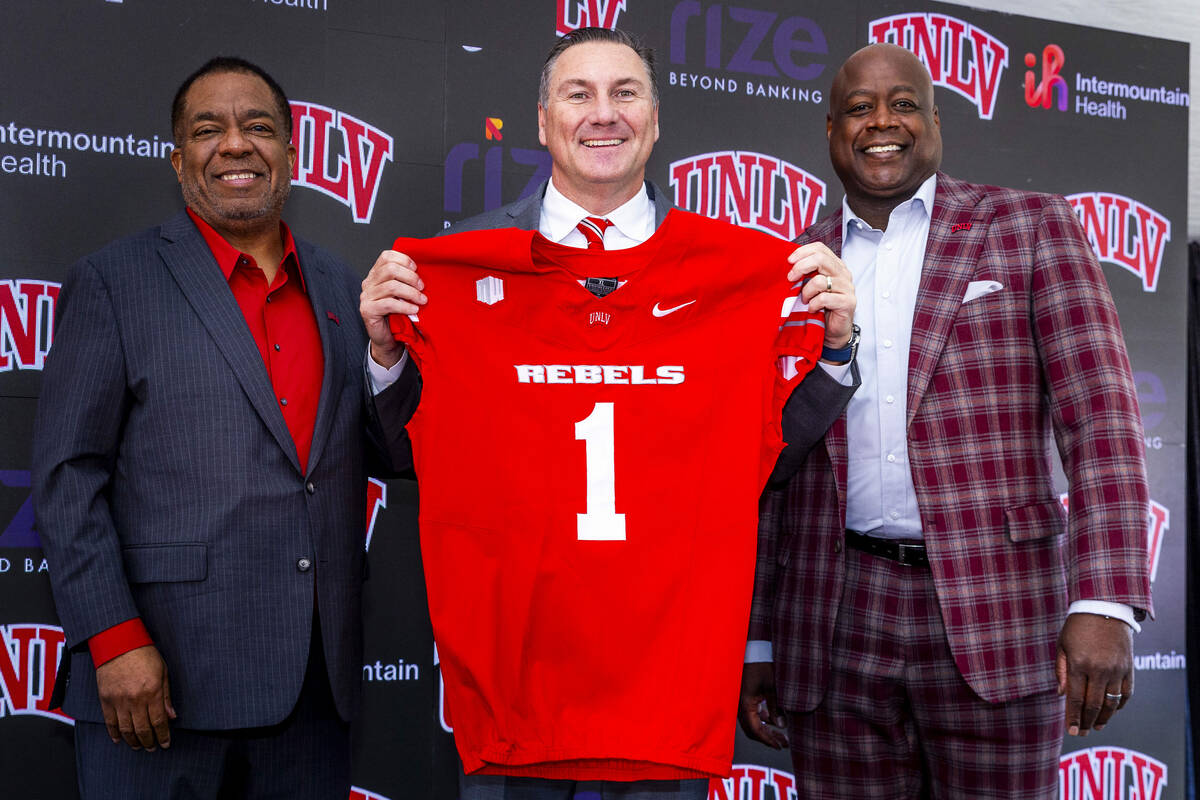 UNLV introduces Dan Mullen, center, with a jersey beside President Keith Whitfield, left, and ...