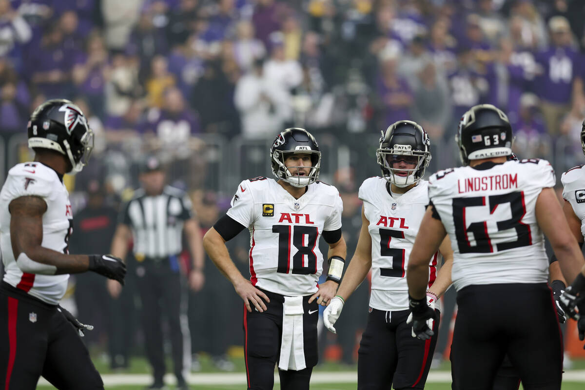 Atlanta Falcons quarterback Kirk Cousins (18) talks with teammates during the first half of an ...