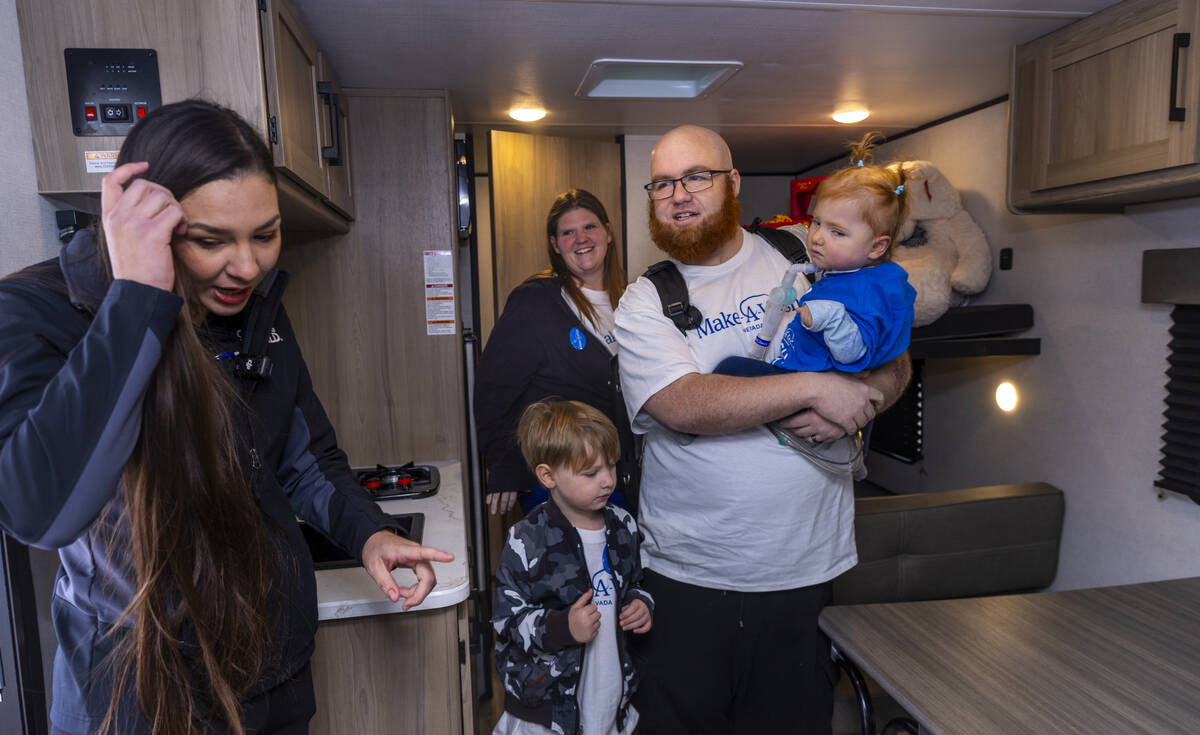 Camping World sales associate Payton Morris gives the King family of Henderson a tour of their ...