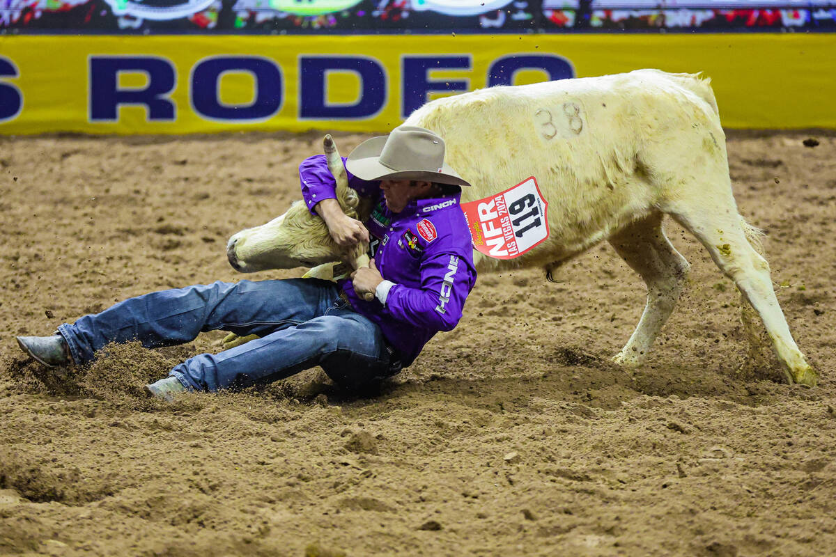 Steer wrestler Tyler Waguespack slides into the dirt to wrestle the steer during the final nigh ...