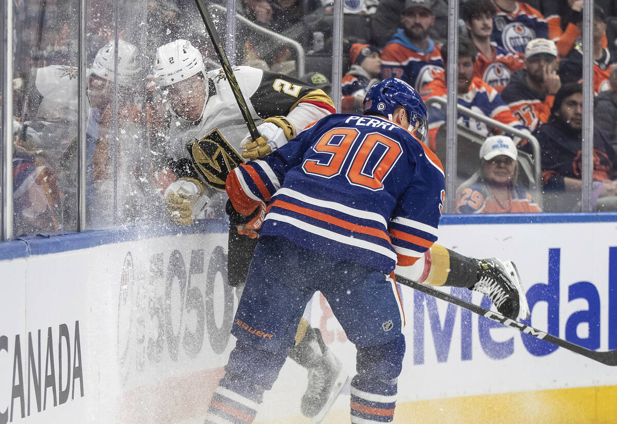 Vegas Golden Knights' Zach Whitecloud (2) is checked by Edmonton Oilers' Corey Perry (90) durin ...