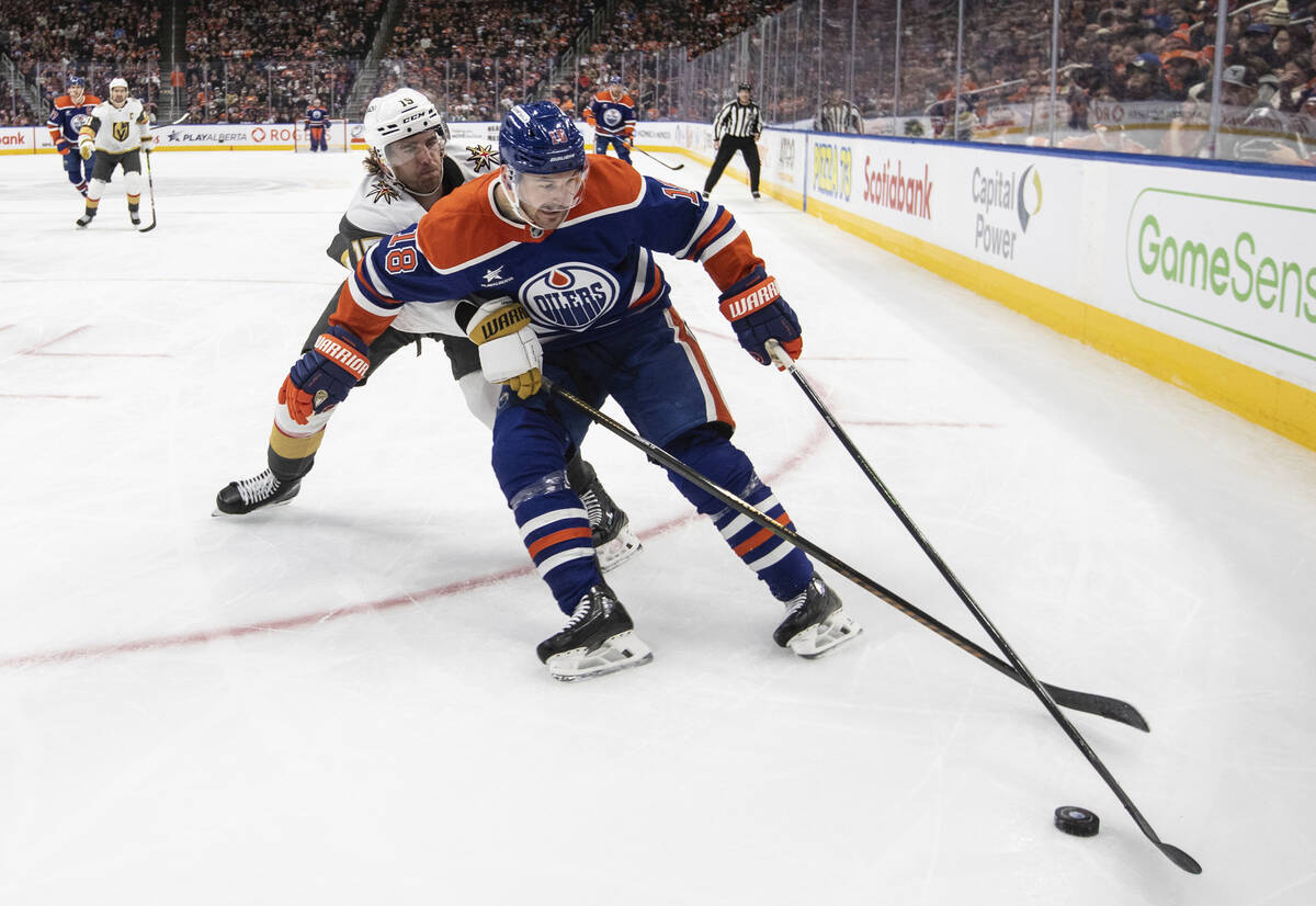 Vegas Golden Knights' Noah Hanifin (15) and Edmonton Oilers' Zach Hyman (18) battle for the puc ...