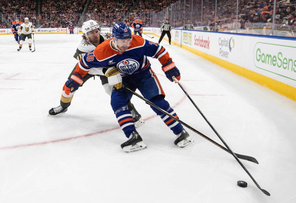 Vegas Golden Knights' Noah Hanifin (15) and Edmonton Oilers' Zach Hyman (18) battle for the puc ...