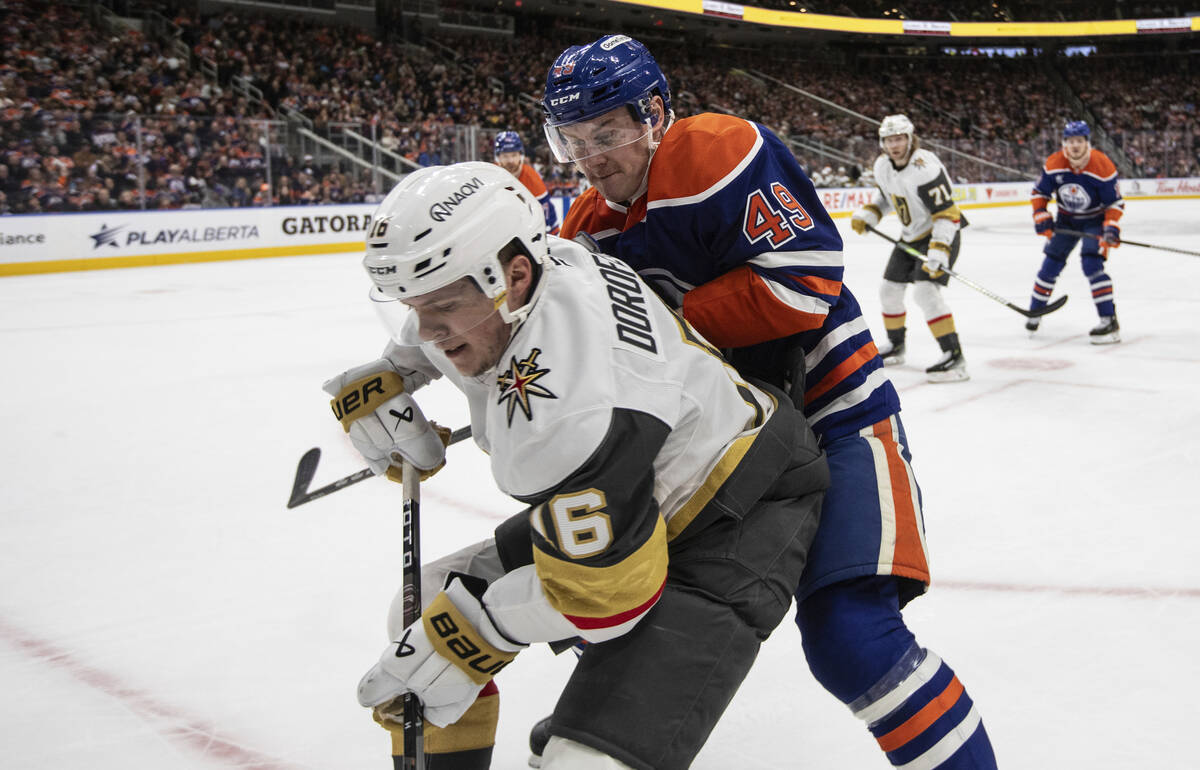 Vegas Golden Knights' Pavel Dorofeyev (16) and Edmonton Oilers' Ty Emberson (49) battle for the ...