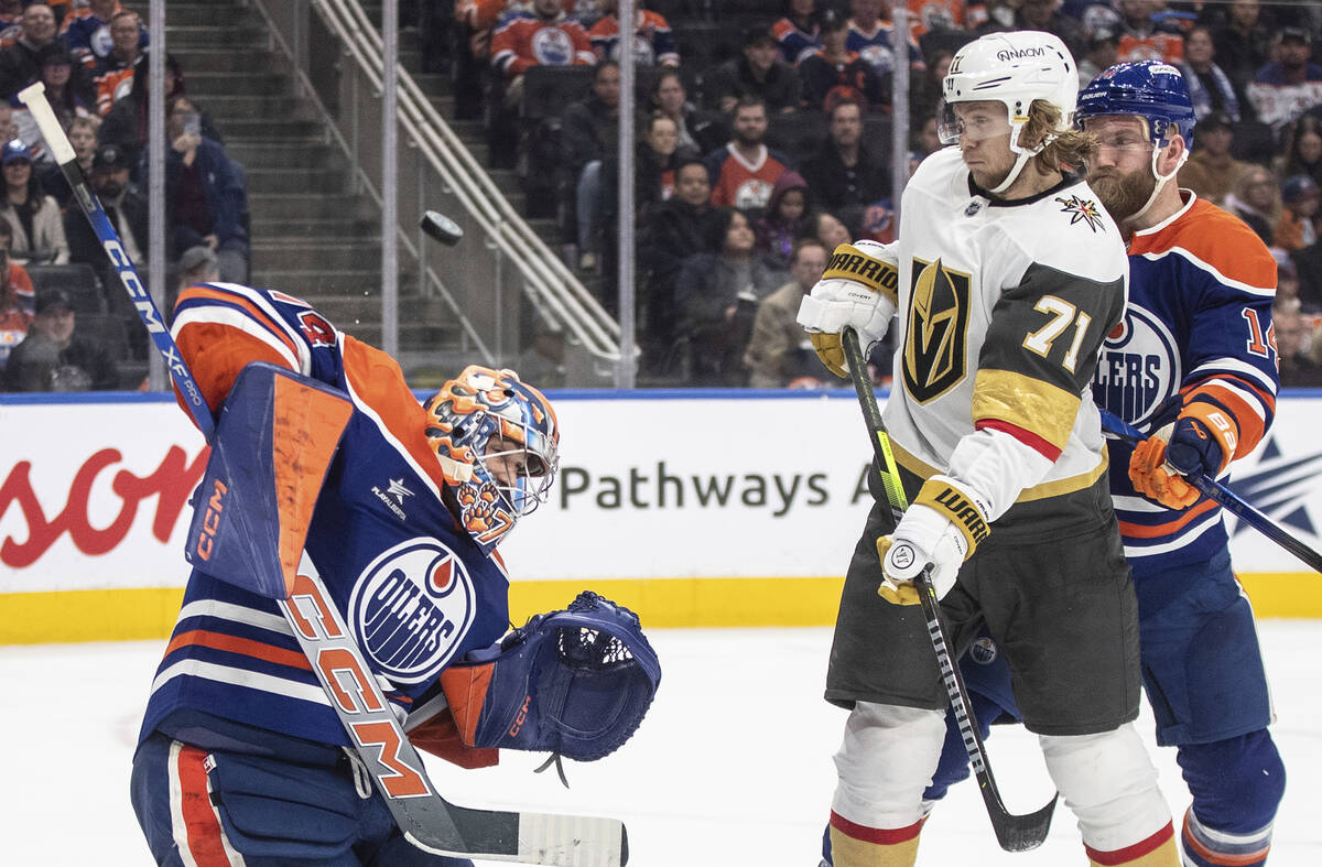 Vegas Golden Knights' William Karlsson (71) and Edmonton Oilers' Mattias Ekholm (14) battle in ...