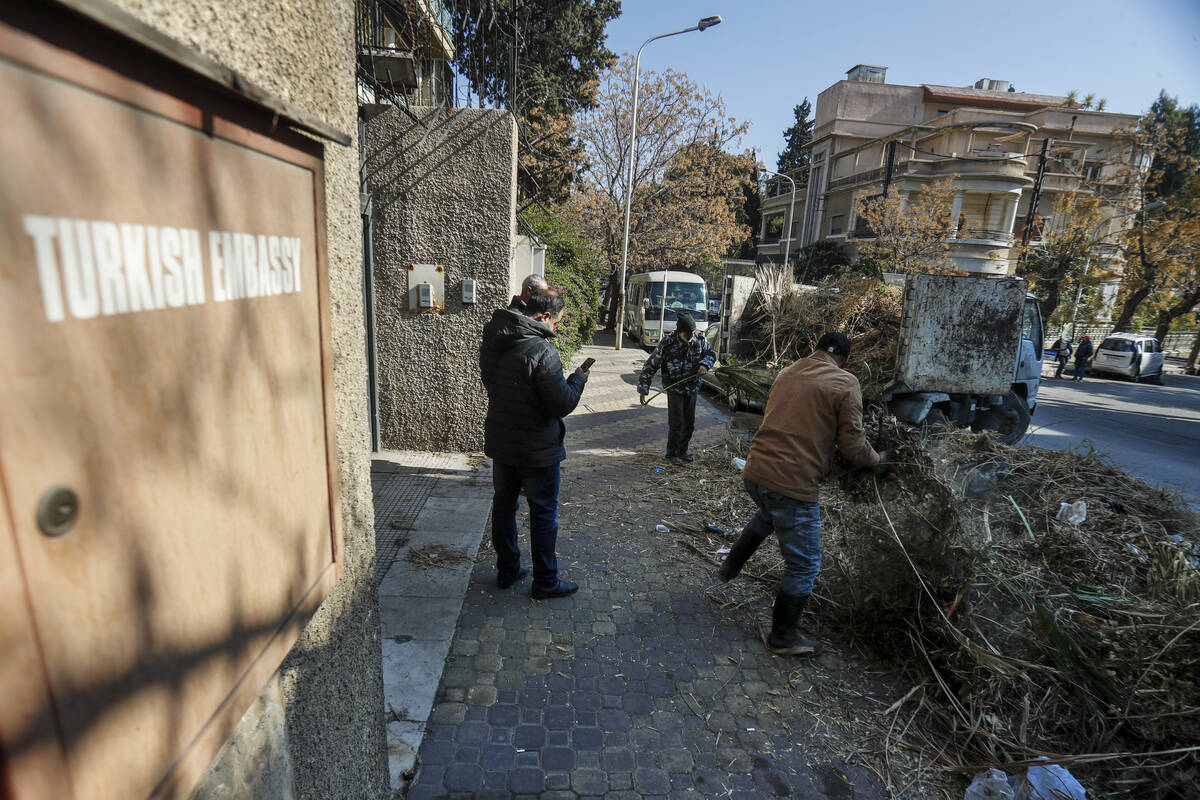 Workers clean outside the Turkish embassy in Damascus, Syria, Saturday, Dec. 14, 2024. (AP Phot ...