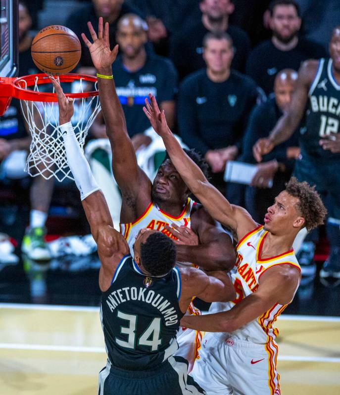 Milwaukee Bucks forward Giannis Antetokounmpo (34) gets to the rim under tight defense by Atlan ...