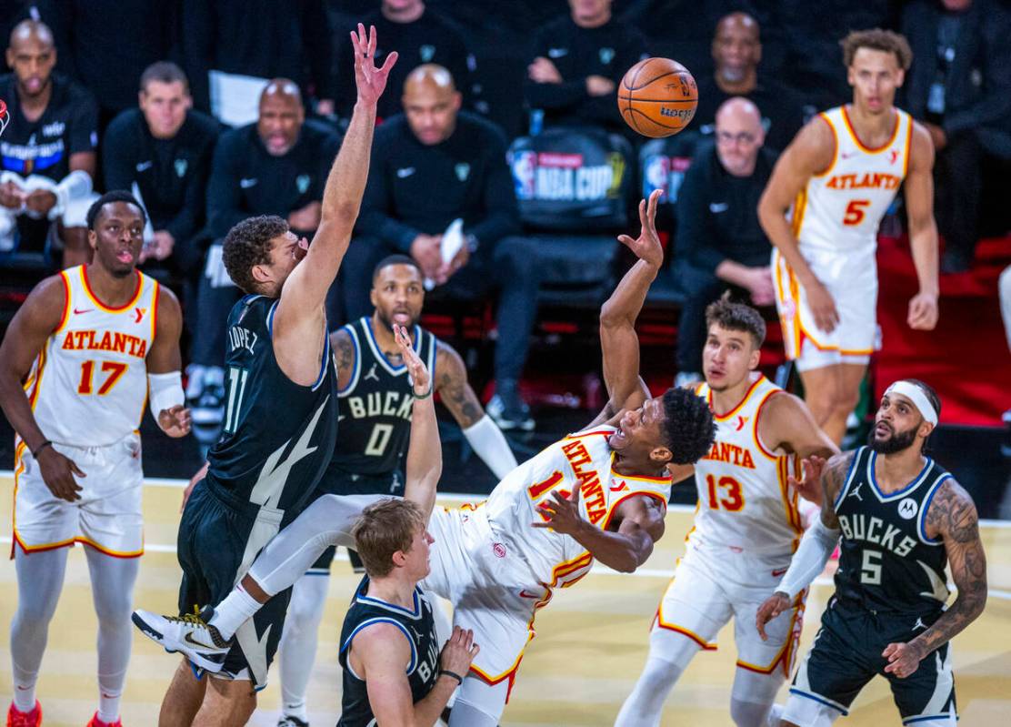 Atlanta Hawks forward De'Andre Hunter (12) gets off a shot while falling back with Milwaukee Bu ...