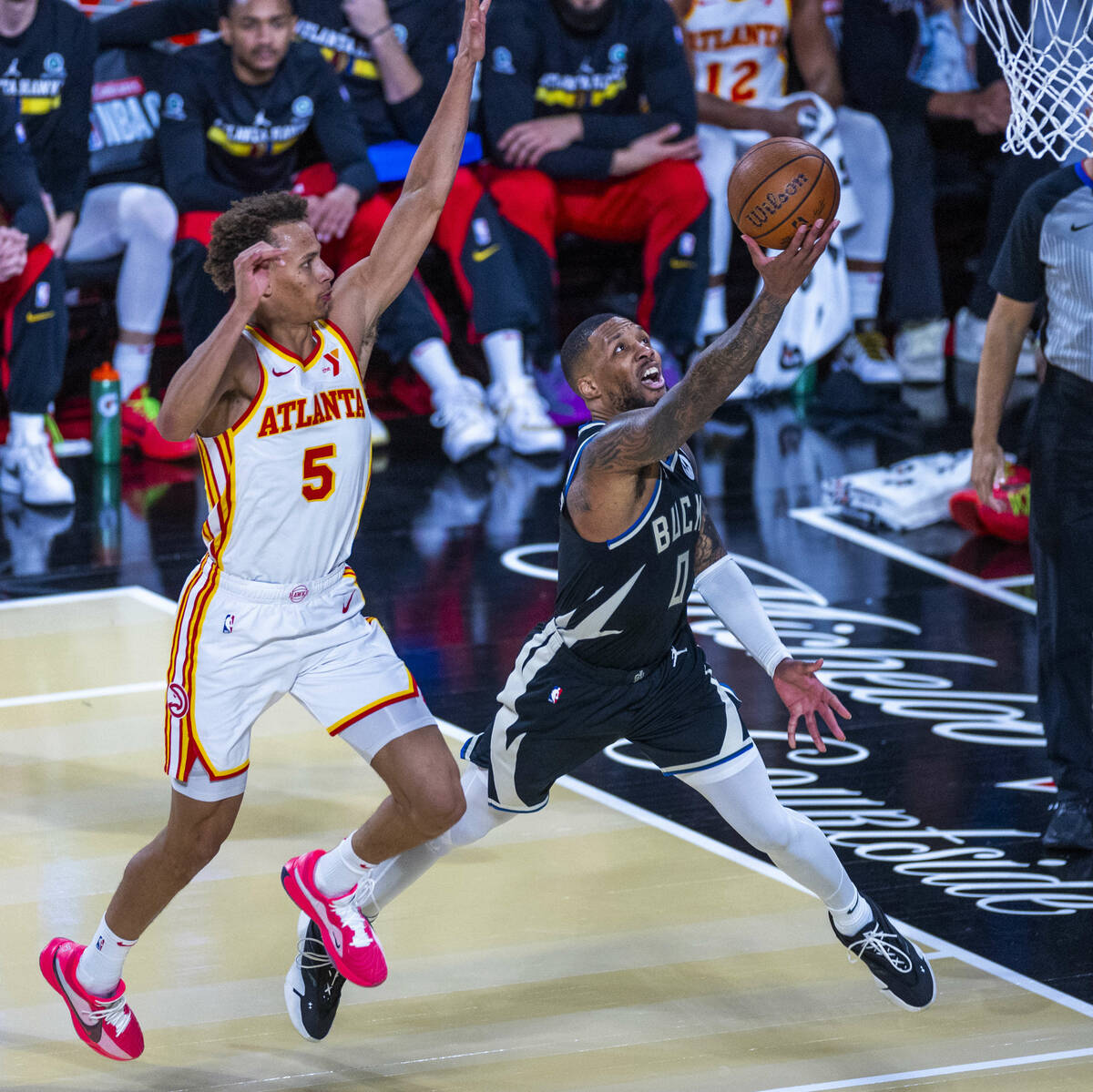 Milwaukee Bucks guard Damian Lillard (0) gets off a shot underneath of Atlanta Hawks guard Dyso ...