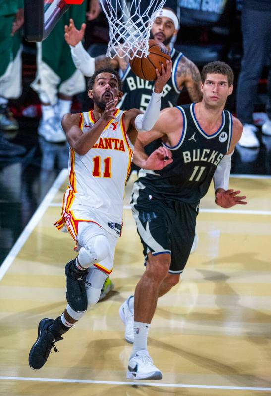 Atlanta Hawks guard Trae Young (11) breaks to the basket past Milwaukee Bucks center Brook Lope ...