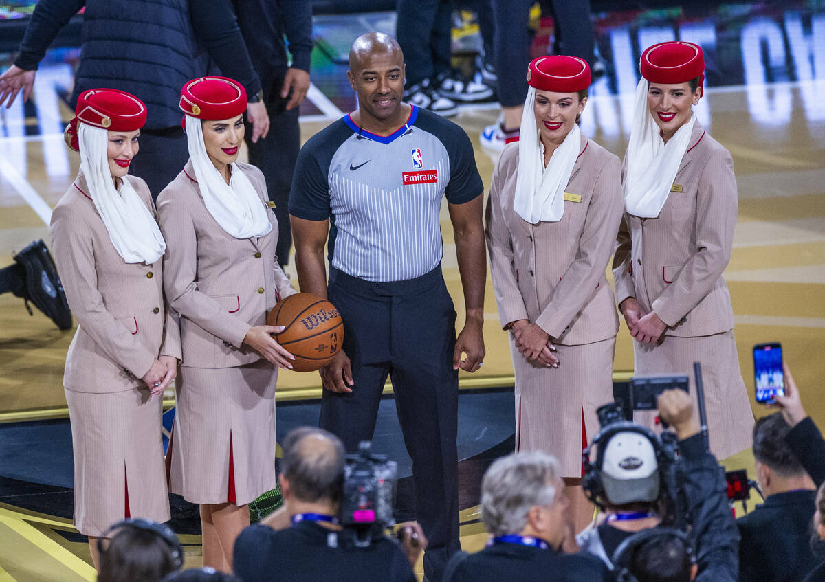 A cabin crew from Emirates joins a referee before the first half of the Milwaukee Bucks and Atl ...