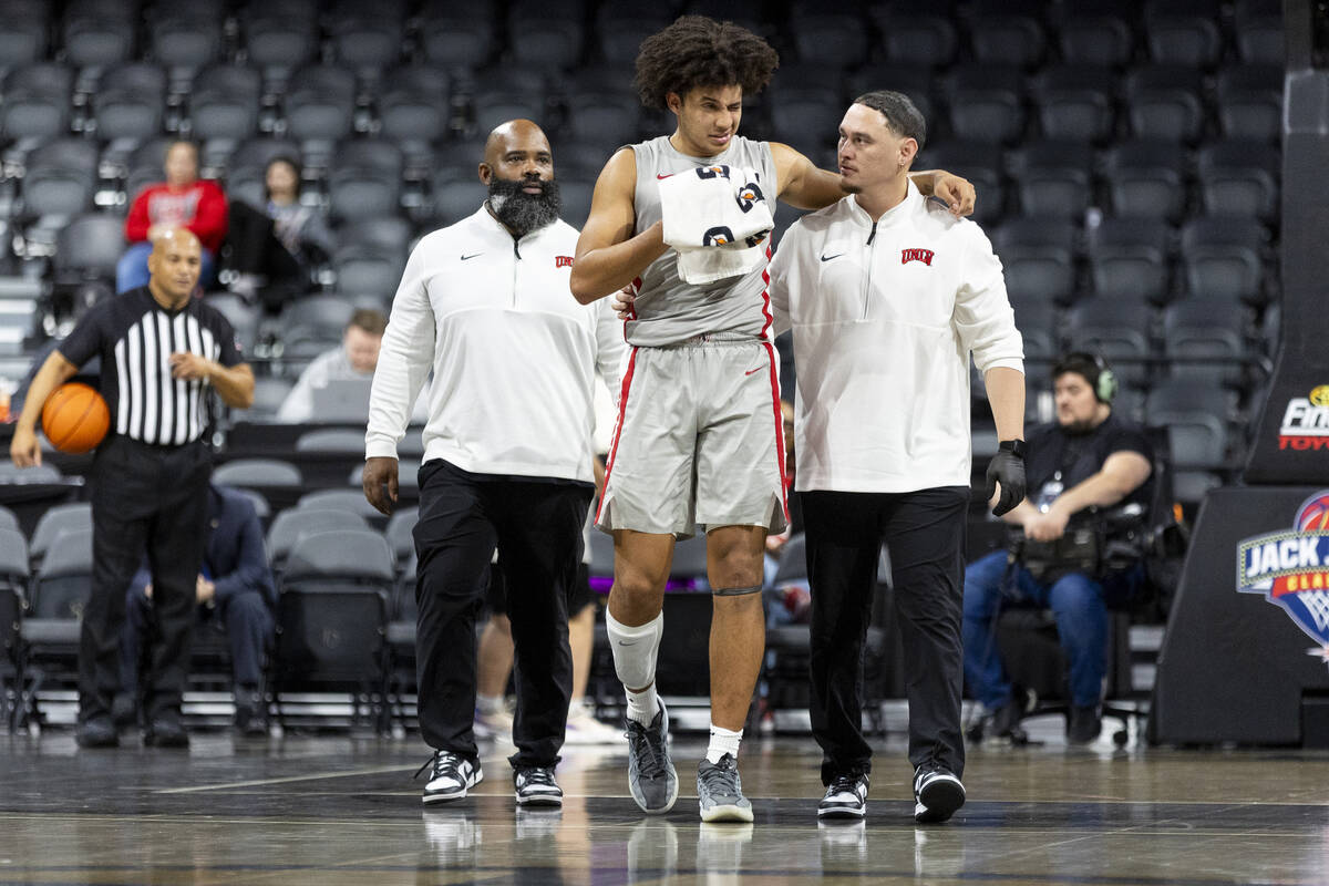 UNLV forward Jalen Hill, center, is helped off the court after taking a blow to the face during ...