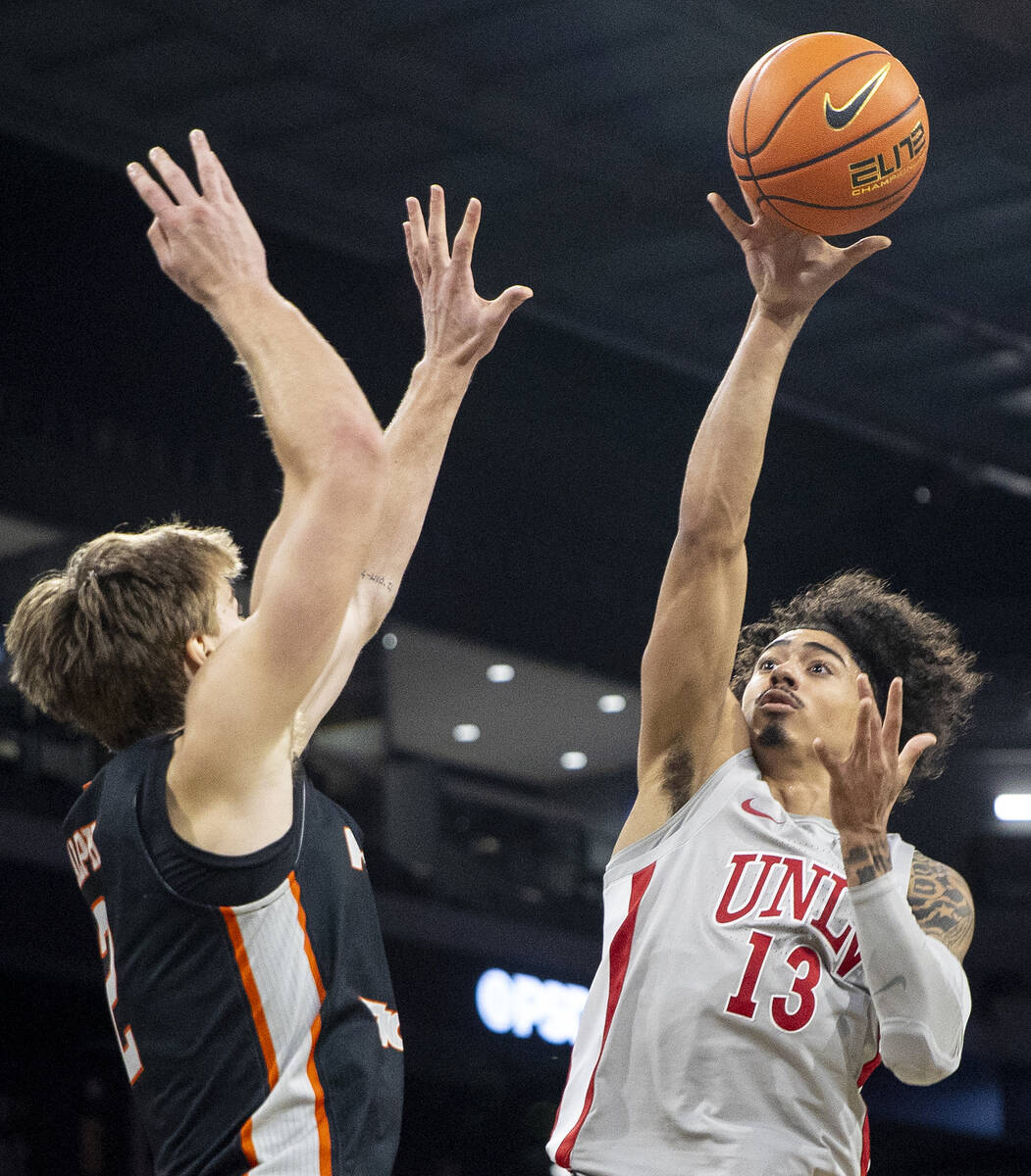 UNLV guard Brooklyn Hicks (13) attempts a shot over Pacific Tigers forward Elias Ralph (2) duri ...