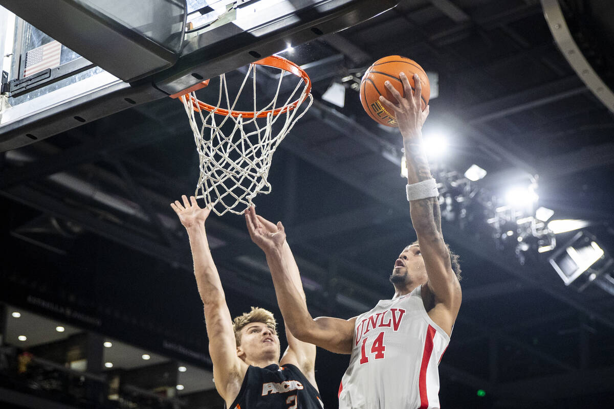 UNLV guard Jailen Bedford (14) attempts a layup past Pacific Tigers forward Elias Ralph, left, ...