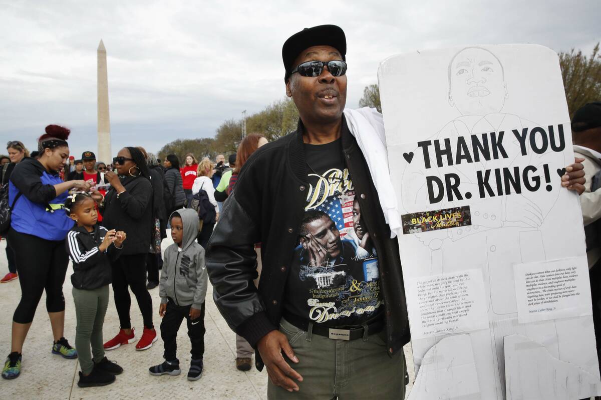 Leonard Patterson, of Manassas, Va., holds a sign thanking Martin Luther King Jr., while attend ...