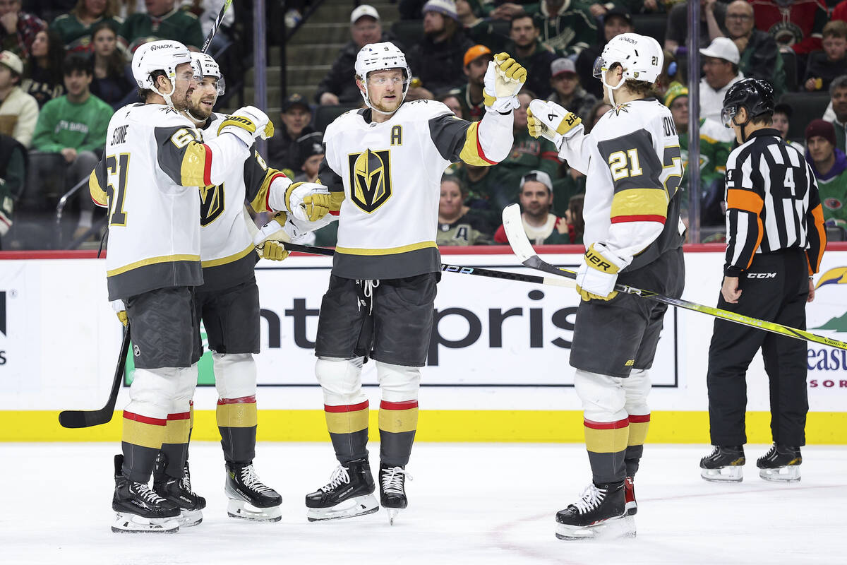 Vegas Golden Knights defenseman Shea Theodore, second left, celebrates his goal with teammates ...