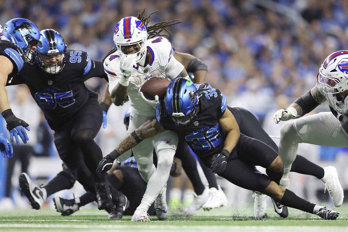 Buffalo Bills running back James Cook, middle, runs against Detroit Lions safety Brian Branch ( ...