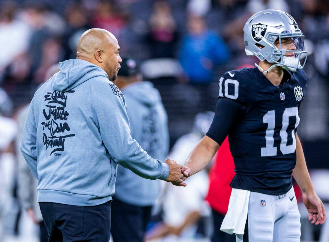 Raiders Head Coach Antonio Pierce greets quarterback Desmond Ridder (10) during warm ups before ...