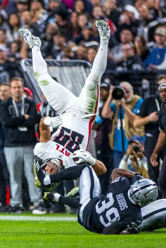 Atlanta Falcons tight end Charlie Woerner (89) flips over Raiders cornerback Nate Hobbs (39) af ...