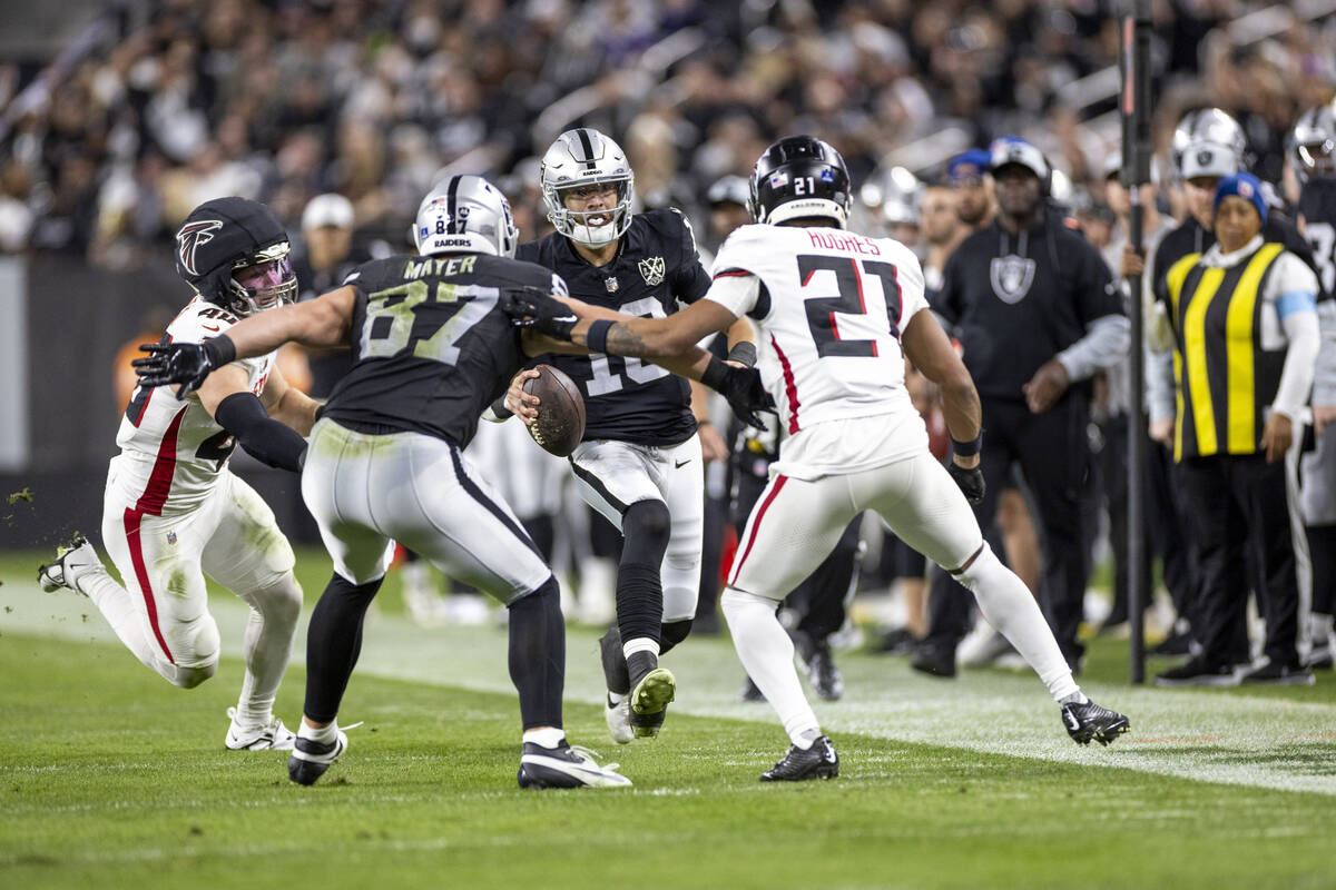 Raiders quarterback Desmond Ridder, center, runs with the ball during the first half of the NFL ...