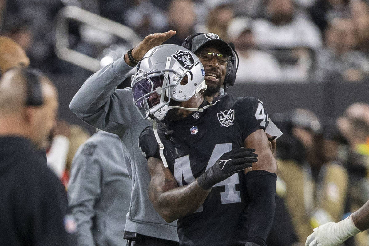 Raiders pass rush specialist DeAndre Carter congratulates Raiders defensive end K'Lavon Chaisso ...