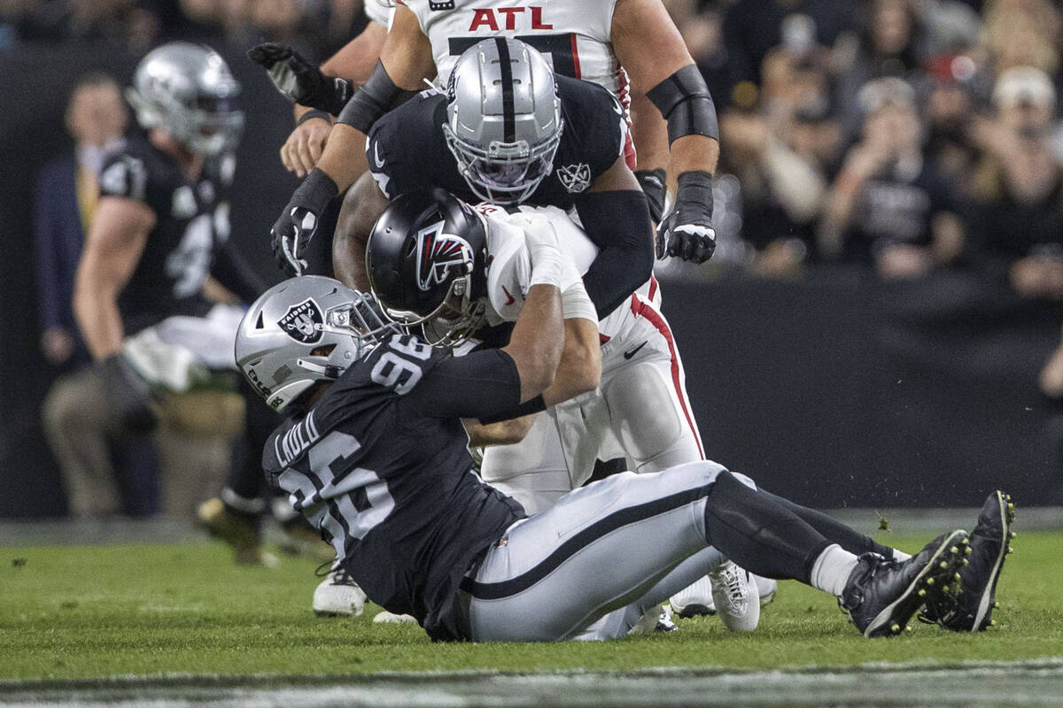 Raiders defensive end K'Lavon Chaisson (44) and defensive tackle Jonah Laulu (96) sack Atlanta ...