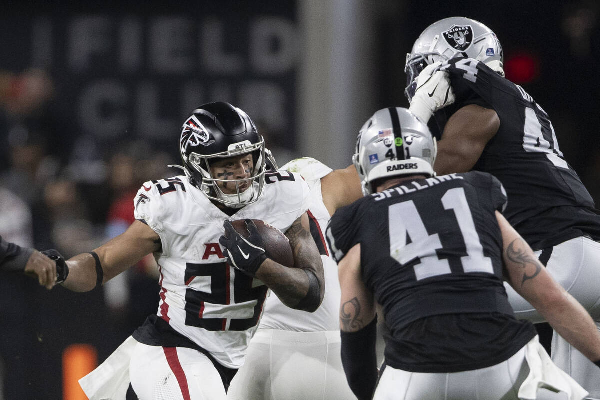 Atlanta Falcons running back Tyler Allgeier (25) rushes towards defensive end K'Lavon Chaisson ...