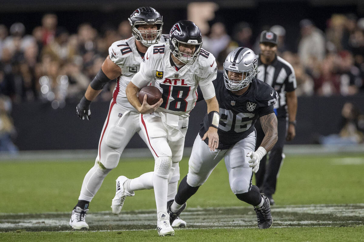 Raiders defensive tackle Jonah Laulu (96) pursues Atlanta Falcons quarterback Kirk Cousins (18) ...