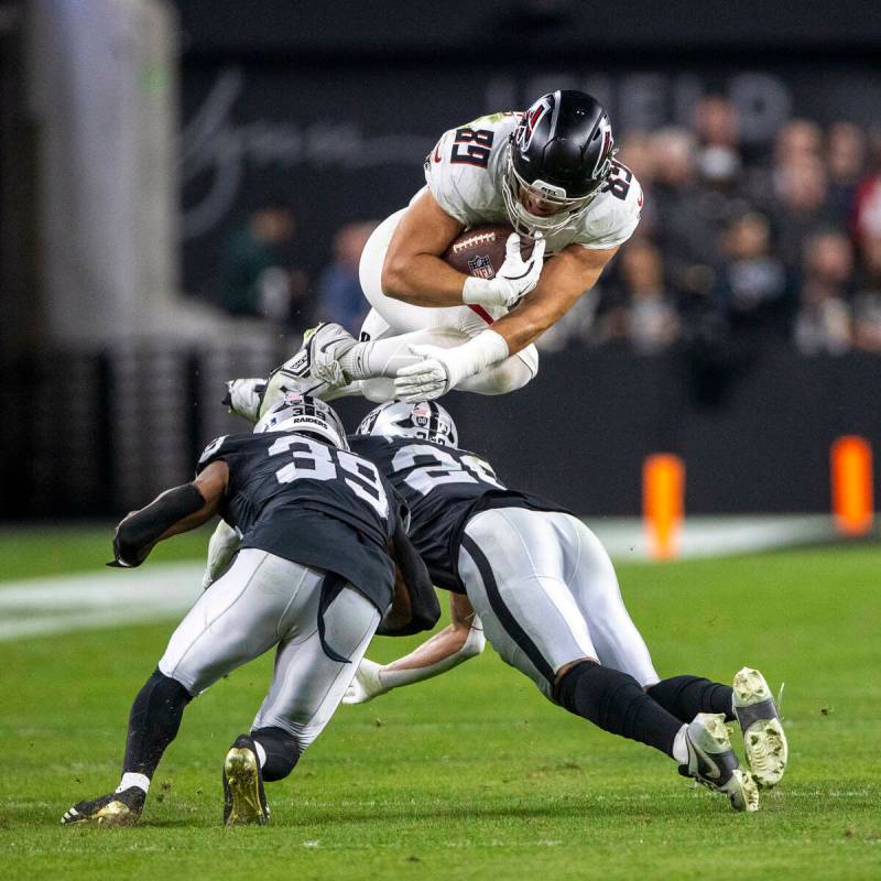 Atlanta Falcons tight end Charlie Woerner (89) leaps over Raiders cornerback Nate Hobbs (39) an ...