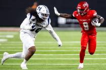 UNLV running back Jai'Den Thomas (9) looks to stiff arm UNR linebacker Tongiaki Mateialona, lef ...