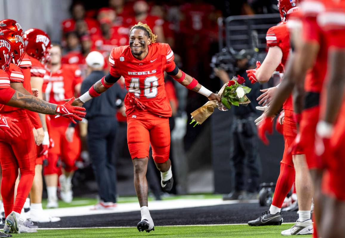 UNLV defensive back Daego Albert (40) high-fives teammates while running onto the field before ...