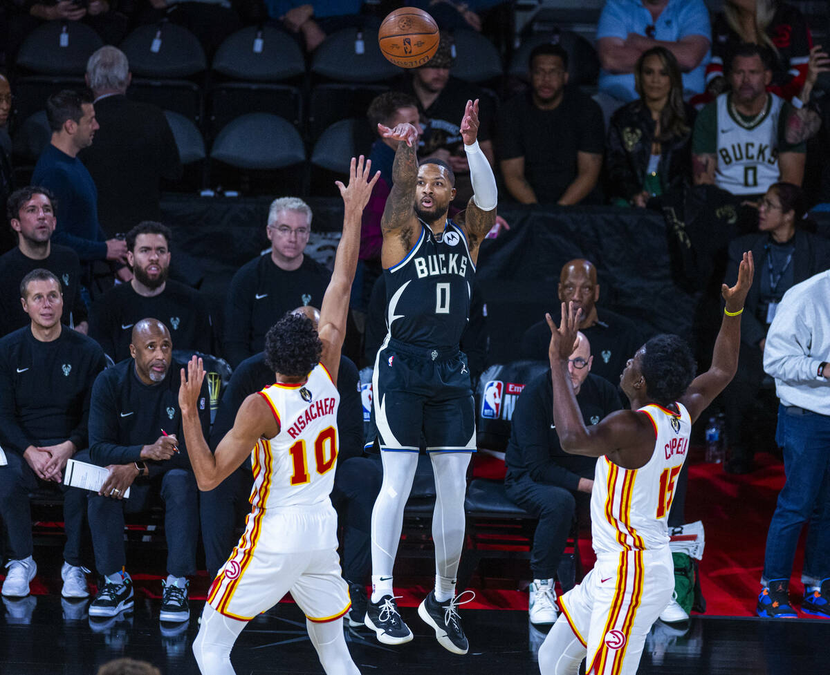 Milwaukee Bucks guard Damian Lillard (0) elevates for a three-point basket between Atlanta Hawk ...