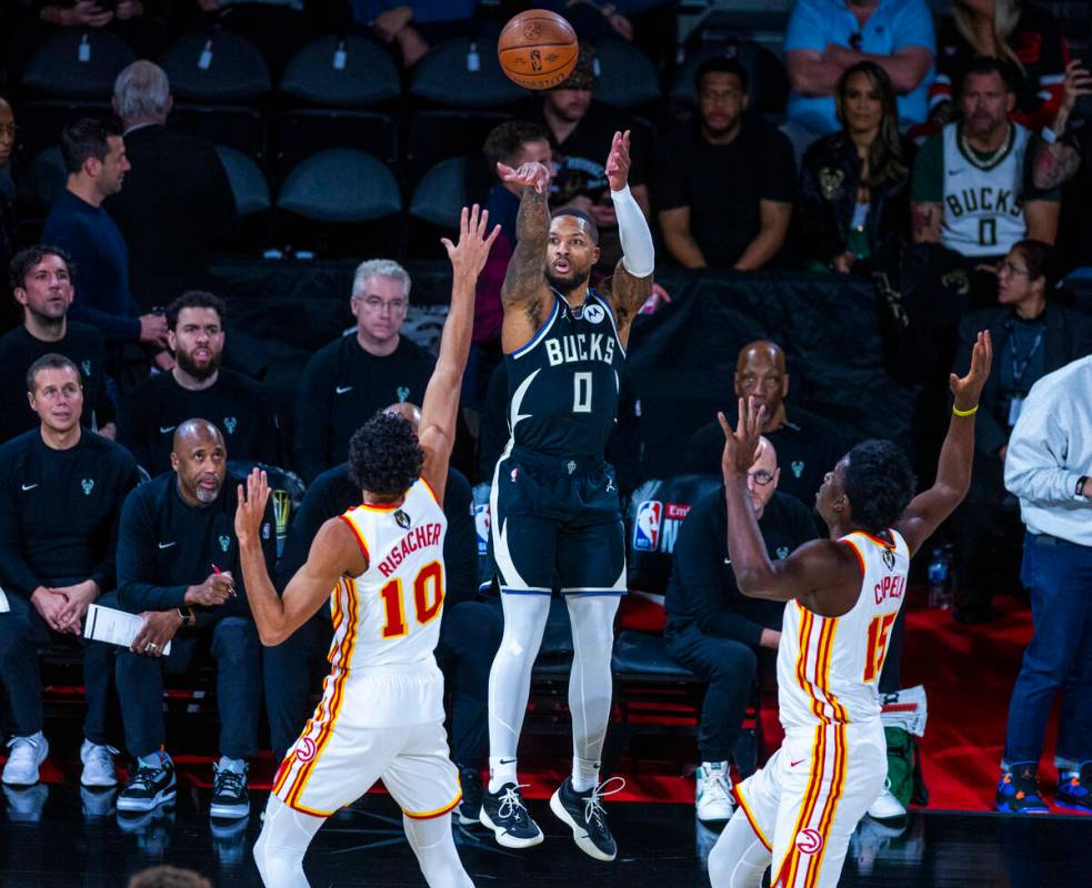 Milwaukee Bucks guard Damian Lillard (0) elevates for a three-point basket between Atlanta Hawk ...