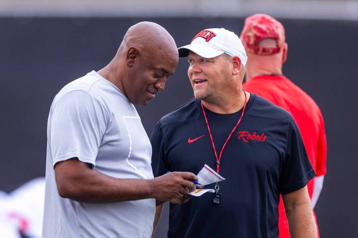 UNLV head coach Barry Odom shares a few words with wide receivers coach Del Alexander as player ...