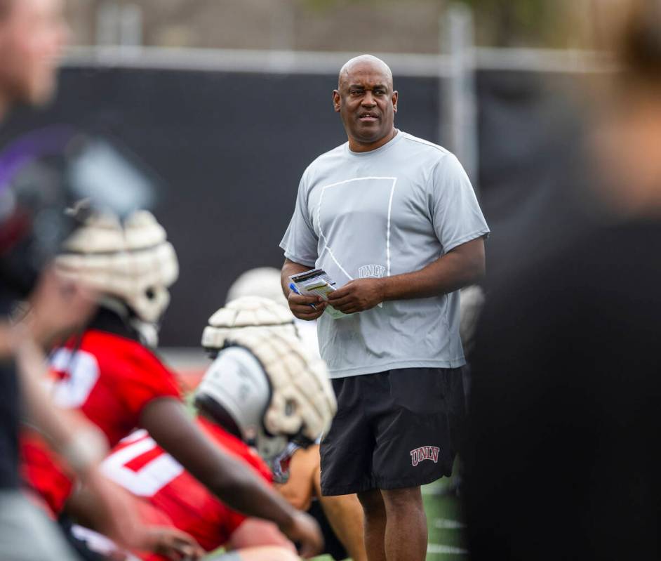 UNLV wide receivers coach Del Alexander watches players stretch during the first day of footbal ...