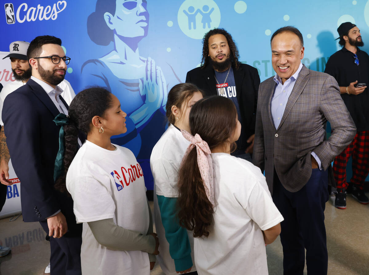 Mark Tatum, right, NBA Deputy Commissioner and Chief Operating Officer, speaks to children as J ...