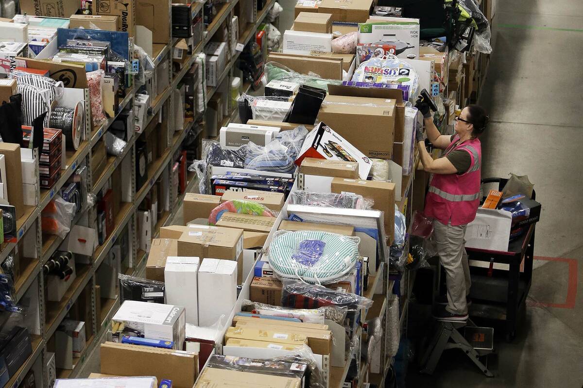 FILE - In this file photo dated Monday, Dec. 1, 2014, a worker fills orders at the Amazon fulfi ...