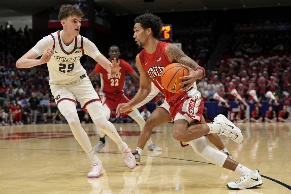 UNLV guard Jailen Bedford, center right, dribbles against Dayton forward Amael L'Etang (29) dur ...