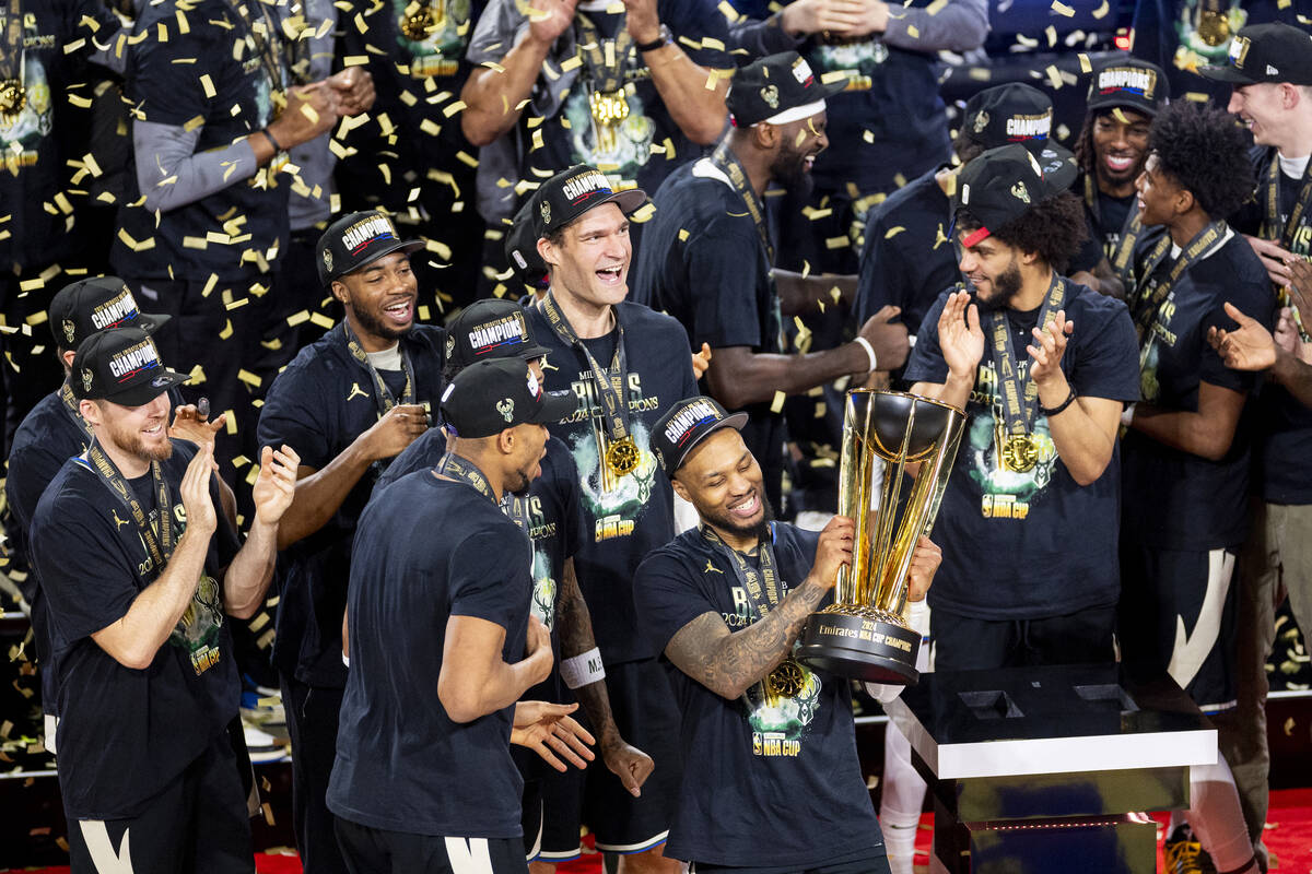 Milwaukee Bucks guard Damian Lillard hoists the NBA Cup trophy after winning the NBA Cup tourna ...