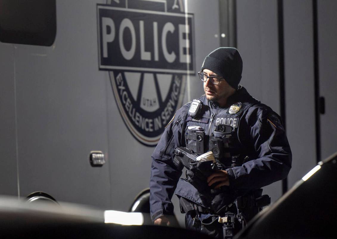 An officer walks past a command trailer as police investigate a crime scene where they say mult ...