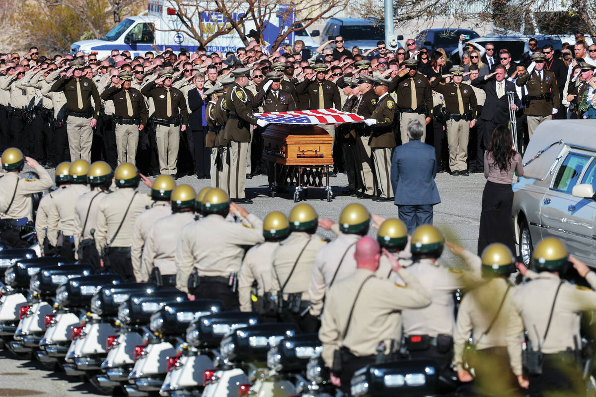 Honor Guard members fold the flag over the casket of Las Vegas police officer Colton Pulsipher ...