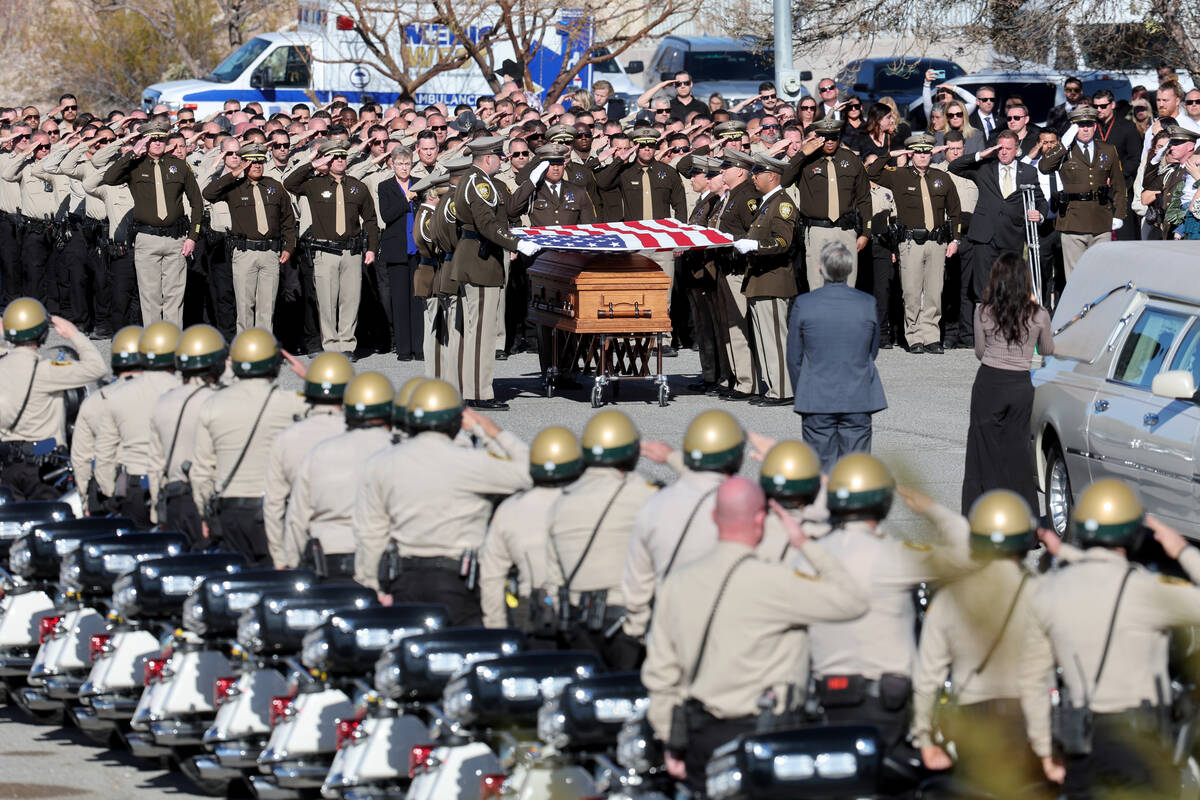 Honor Guard members fold the flag over the casket of Las Vegas police officer Colton Pulsipher ...